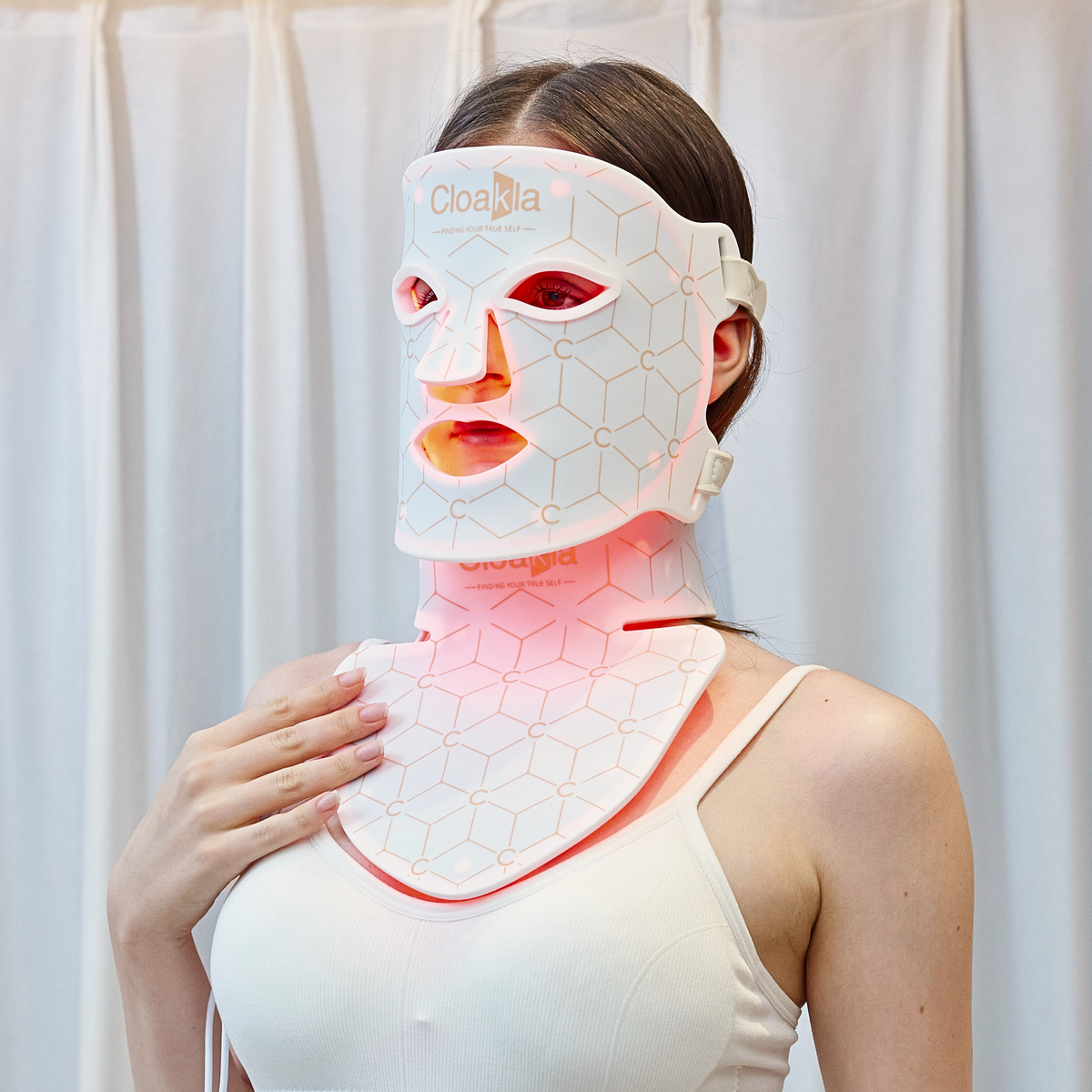 Cloakla K11 red light therapy face mask and neck panel worn by woman showing red LED light treatment